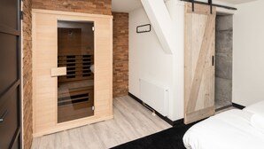 A modern bedroom with a wooden wardrobe, a sliding door, and a black rug. - Renesse Bomont Sauna by Interhome (Renesse)