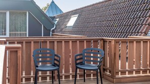 A wooden deck with two chairs and a wooden fence. - Renesse Bomont Sauna by Interhome (Renesse)