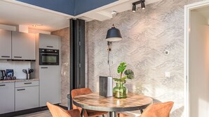 A modern kitchen with white cabinets, a black oven, and a countertop with kitchen utensils. - Renesse Bomont Sauna by Interhome (Renesse)