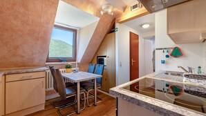 A compact kitchen with a dining area, a window with a view, and a small kitchenette.