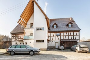 Ein zweistöckiges Haus mit einem geneigten Dach, einem Balkon und einer Garage.