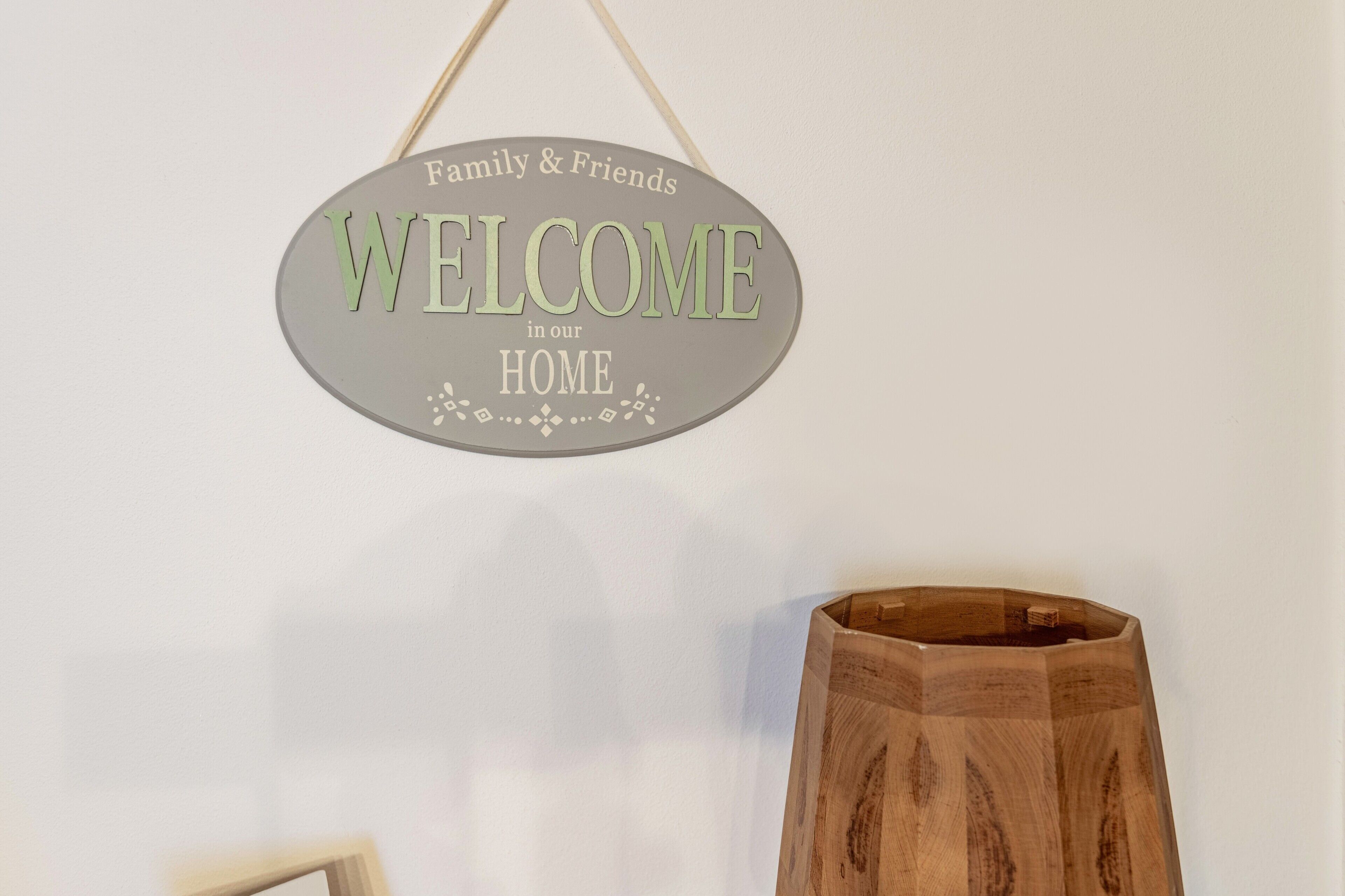 A welcome sign with 'Family & Friends Welcome in our HOME' text.