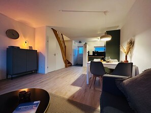 Una sala moderna con sofá, una mesa de centro y un comedor con sillas y una mesa.