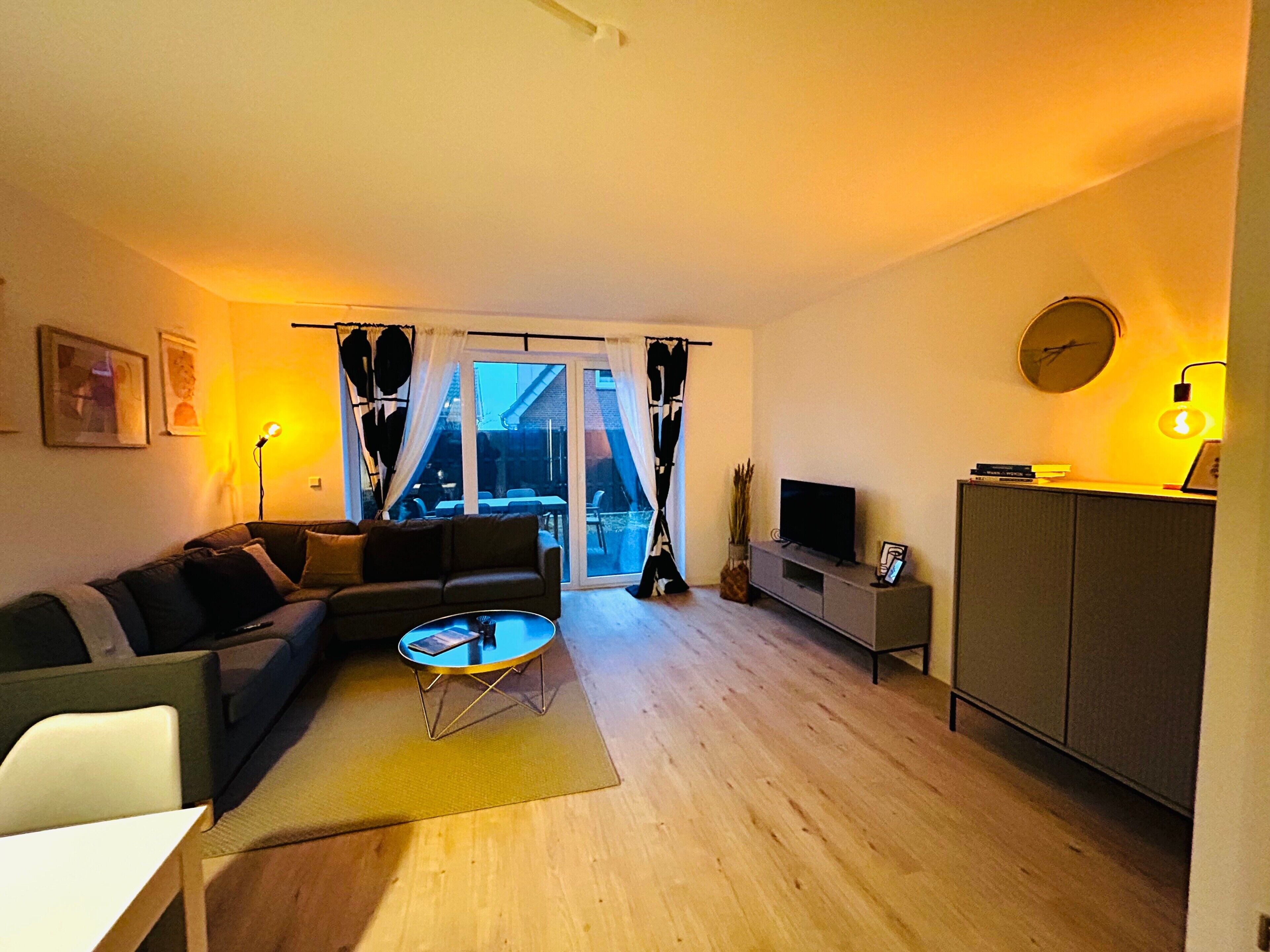 A living room with a sofa, coffee table, TV, and a cabinet.