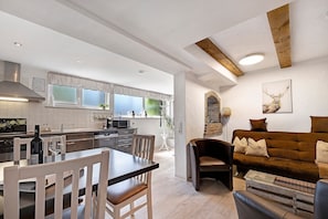 A modern kitchen with a dining area, a sofa, and a fireplace. - Apartment 'Knodel No. 1' with Shared Terrace, Garden & Wi-Fi (Sachsenheim)