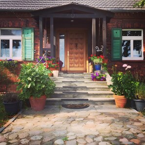 A brick house with a wooden front door, green shutters, and a number '23' sign. - Apartment 'Schwalbennest' with Shared Terrace, Shared Garden and Wi-Fi (Eldetal OT Wredenhagen)