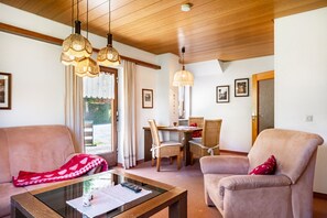 Una sala de estar con dos sofás, una mesa de centro y un comedor con sillas y una mesa.