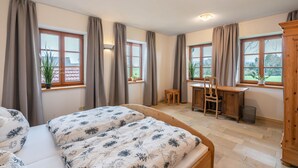 Ein Schlafzimmer mit zwei Betten, einem Schreibtisch und einem Stuhl.