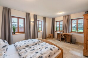 A bedroom with two beds, a desk, and a chair. - Holiday Apartment 'Landnest' with Mountain View, Balcony and Wi-Fi (Prutting)