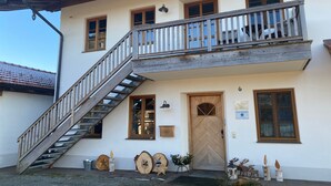 Ein zweistöckiges Gebäude mit einer Holztreppe, einem Balkon und einer Tür mit der Nummer 6.