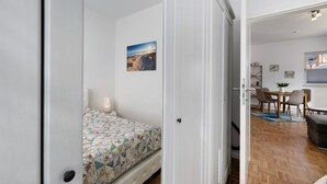 A bedroom with a bed, a bedside table, and a wall-mounted picture. - Holiday Apartment 'Tu Huus' with Private Garden and Wi-Fi (Wesselburen)