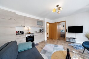 Una sala de estar moderna con un sofá, una mesa de centro y un televisor de pantalla plana.