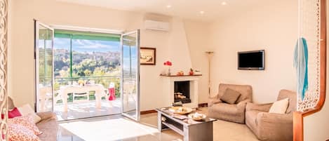 A spacious living area with a sofa, coffee table, and a fireplace.