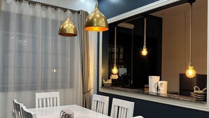 A dining area with a white table, white chairs, and pendant lights. - Luxury home,  located in a quiet and calm area, Home away from home. (Entebbe)