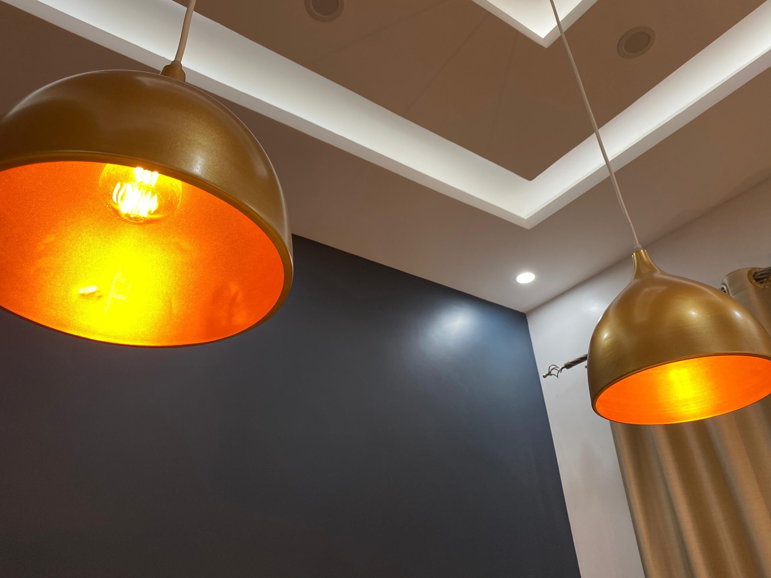 Two pendant lights with a gold finish hanging from the ceiling.