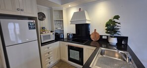 Deluxe Apartment, Courtyard View | Private kitchen | Coffee/tea maker, electric kettle, dining tables