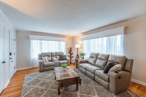 A living room with two sofas, a coffee table, and a rug.