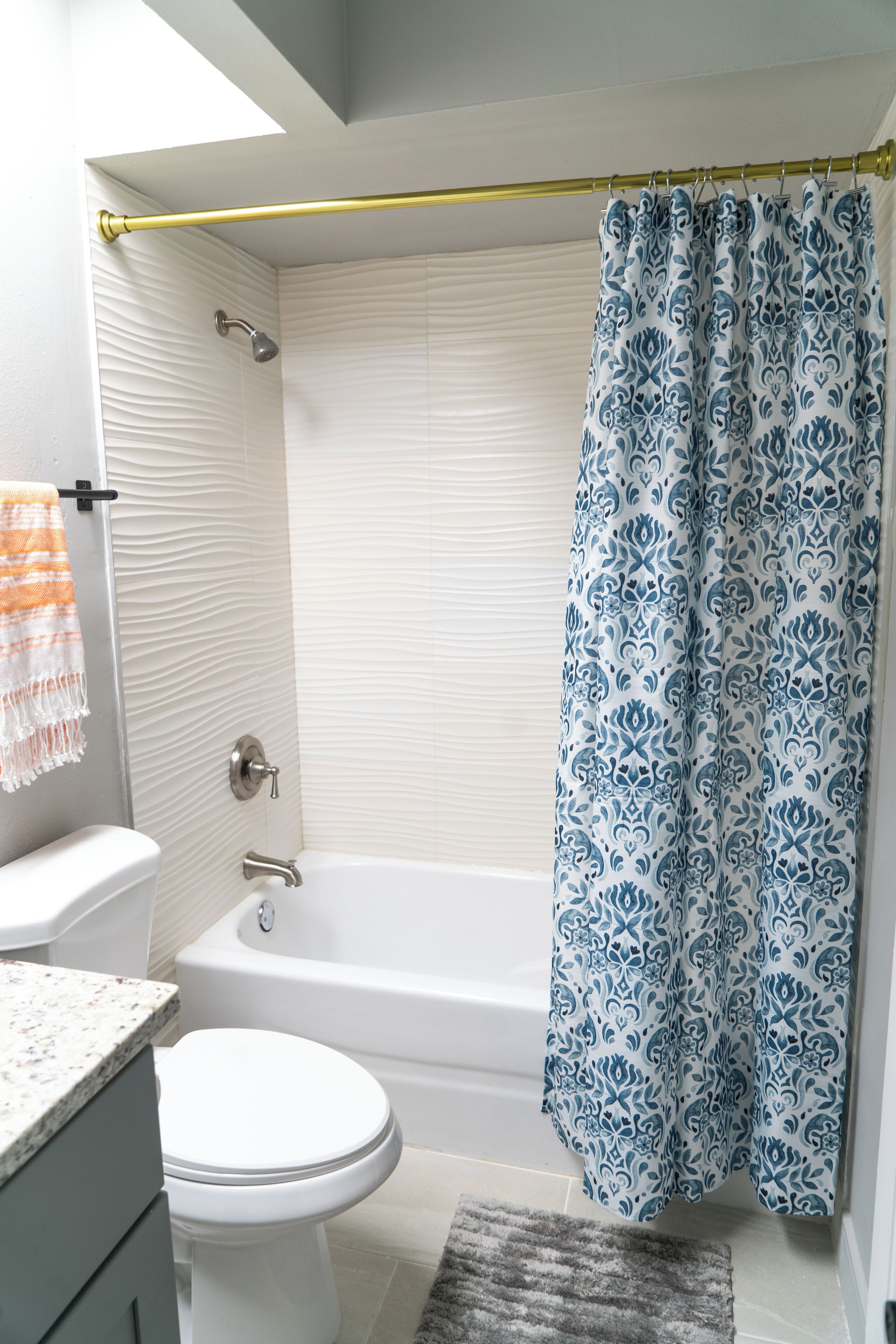 A bathroom with a bathtub, toilet, and shower curtain.