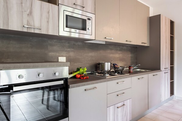 A modern kitchen with stainless steel appliances, a built-in oven, and a gas stove.