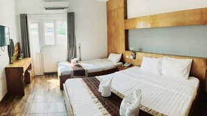 Una habitación de hotel con dos camas, un escritorio, un televisor y un equipo de aire acondicionado.
