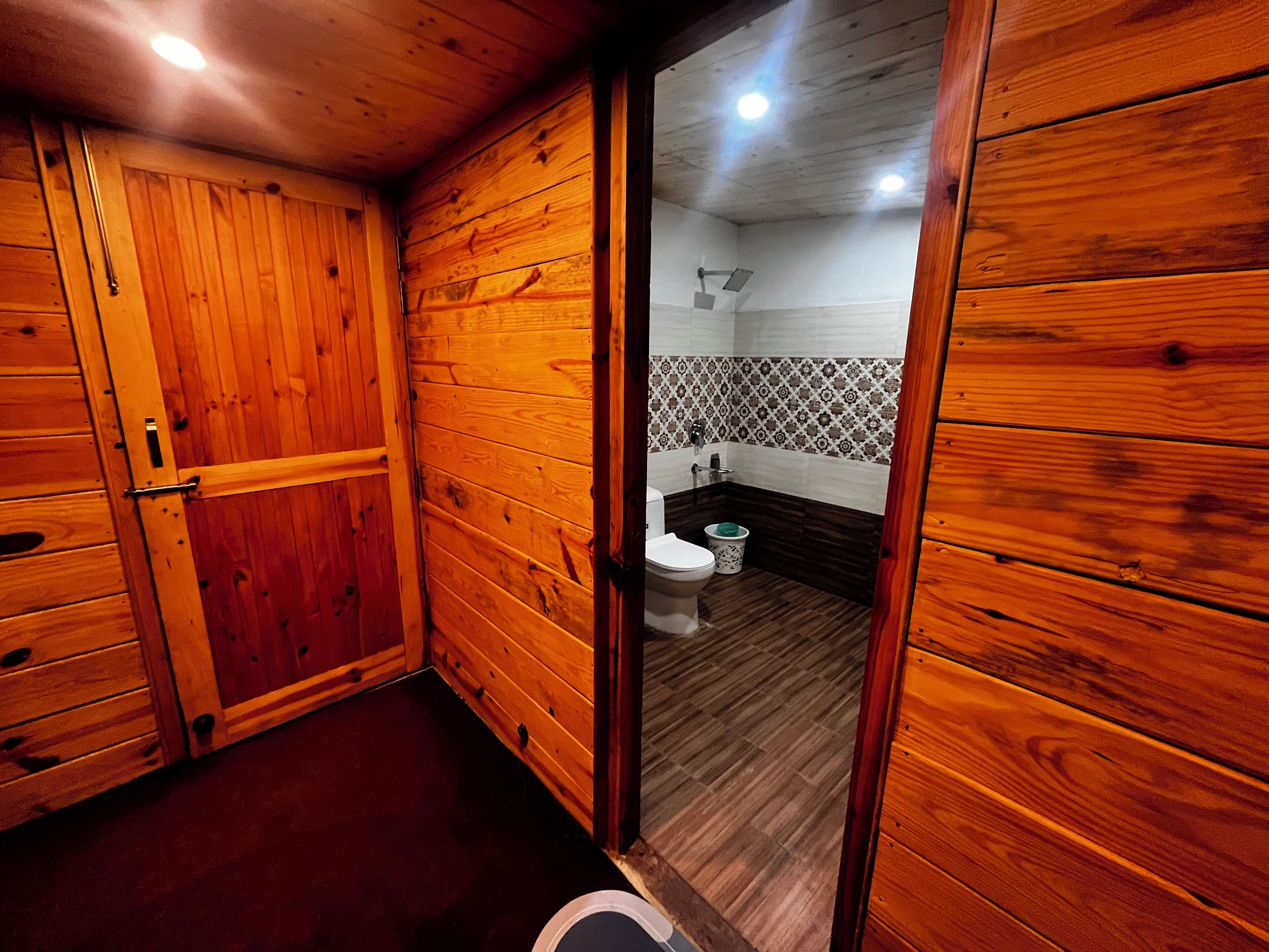 A wooden-paneled bathroom with a toilet and a bidet.