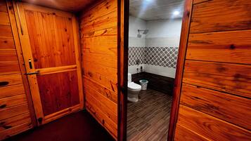 A wooden-paneled bathroom with a toilet and a bidet.
