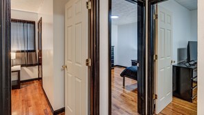 A hallway with wooden flooring, white doors, and a visible closet. - Centralized Modern Home in Johnson City (Johnson City)