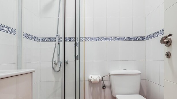 Une salle de bain avec une douche à parois de verre, des toilettes et un lavabo.
