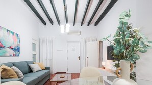 Un salon moderne avec une table basse en verre, un canapé et un coin repas avec des chaises.