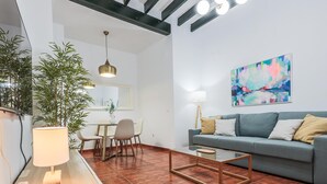 Un salon moderne avec un canapé, une table basse et un coin repas.