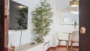 Moderni keittiö, jossa on puinen työtaso, suuri peili ja bambukasvi.