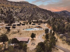 Un complexe hôtelier comprenant plusieurs chalets, une piscine et un chemin sinueux.