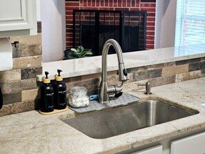 A kitchen with a stainless steel sink, a faucet, and soap dispensers. - 4 Bedroom Rambler W/Game Room (Rockwall)