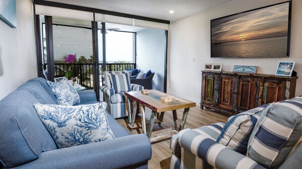 A living room with a sofa, chairs, a wooden table, and a cabinet.
