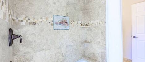 Ein Badezimmer mit Badewanne, geflieste Wände und einer Duschkabine.