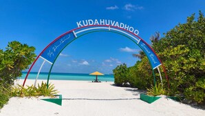 A beach entrance archway with the name 'KUDAHUVADOO' and a sign for 'Sunset Beach.' - Oceana Inn Maldives (Kudahuvadhoo)