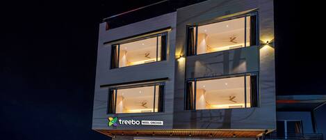 Un edificio moderno con múltiples ventanas y un cartel que dice 'treebo NEEL ORCHID'.