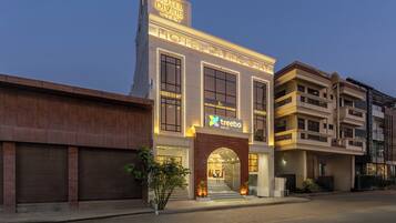 A hotel named "Hotel Divine Stay" with a modern facade, a prominent entrance, and a sign for "Treebo" adjacent to it.