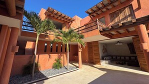 A courtyard with a pool, palm trees, and a seating area with a sofa and a table. - Luxury Eco in Troncones Casa Mia (Troncones)