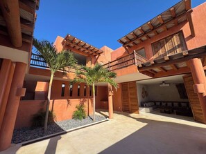 Un cortile con piscina, palme e un'area salotto con divano e tavolo.
