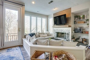 Ein gemütliches Wohnzimmer mit Kamin, Fernseher und einer bequemen Sitzecke.