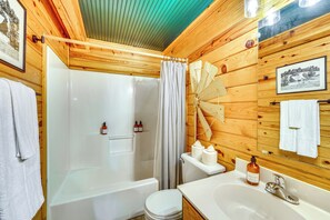 A wooden cabin bathroom with a bathtub, toilet, and sink. - 5 Mi to Beaver Lake: Family Cabin w/ Game Room (Eureka Springs)