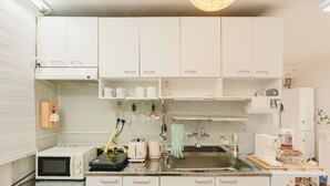 A modern kitchen with white cabinets, a microwave, a toaster, and a sink.