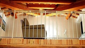 Una escalera que lleva a un balcón de madera con barandilla.