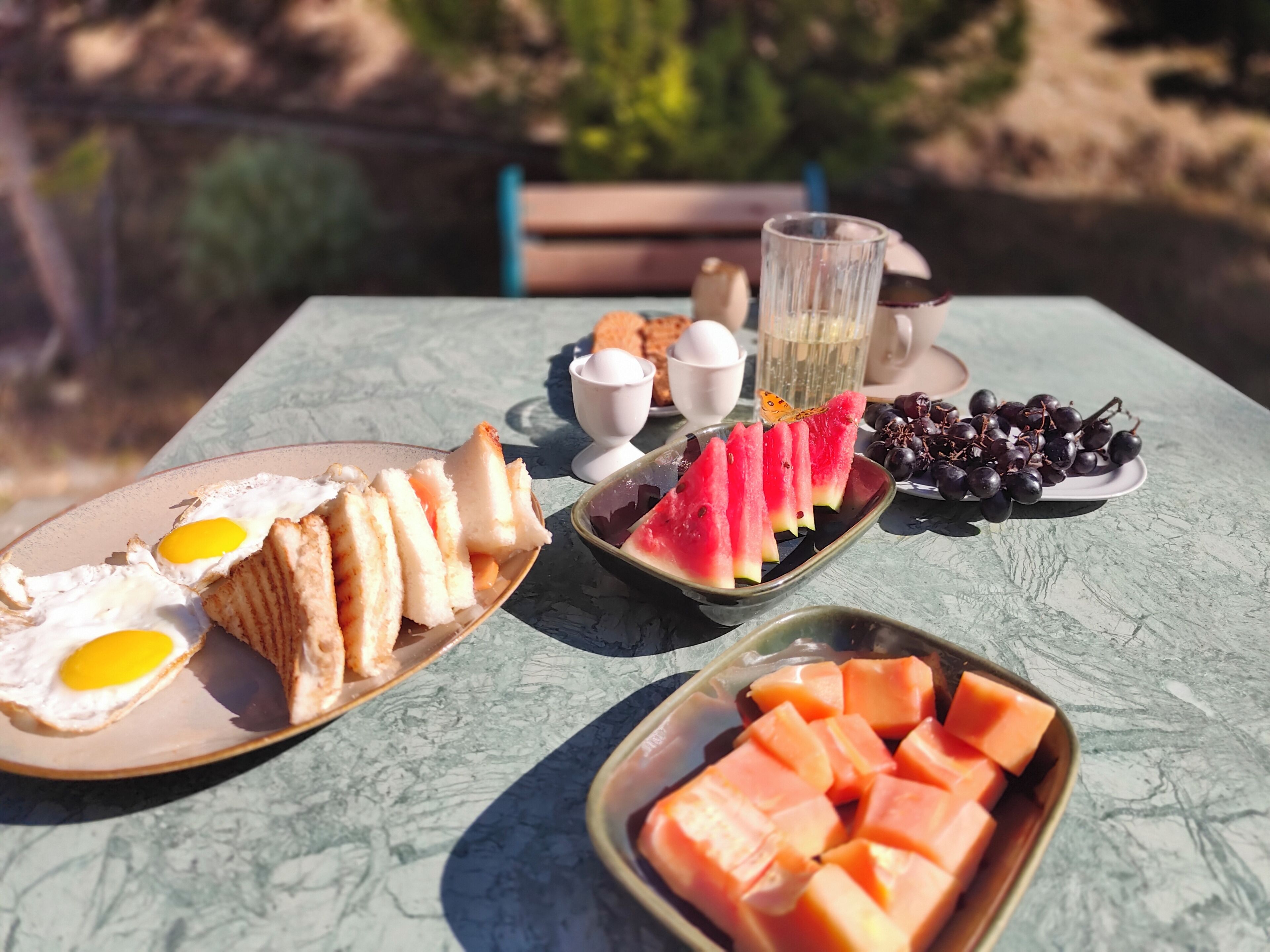 A table with food items including eggs, bread, watermelon, and grapes.