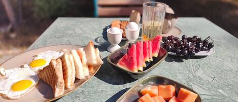 A table with food items including eggs, bread, watermelon, and grapes.