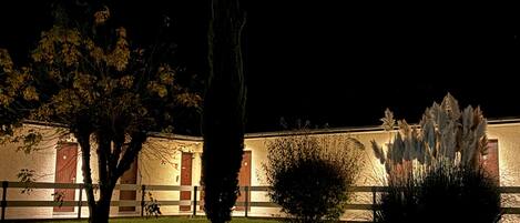 A building with a simple facade, a parking lot, and a well-lit entrance.