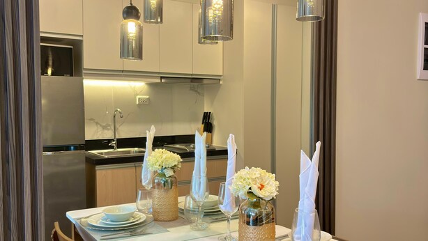 Comedor con una mesa dispuesta para cuatro, con platos, vasos y cubiertos.