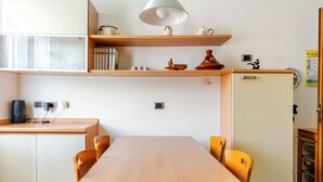Una cocina compacta con mesa, sillas y un refrigerador.