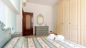 Un dormitorio con cama, cómoda, armario y espejo.